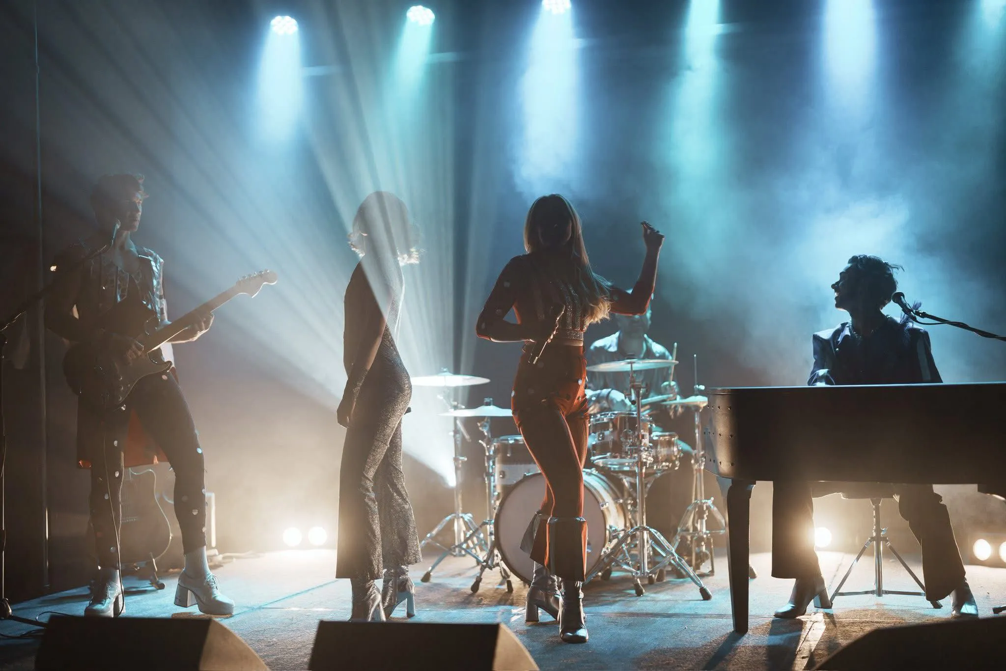Band silhouette against smoky white backdrop with spotlights