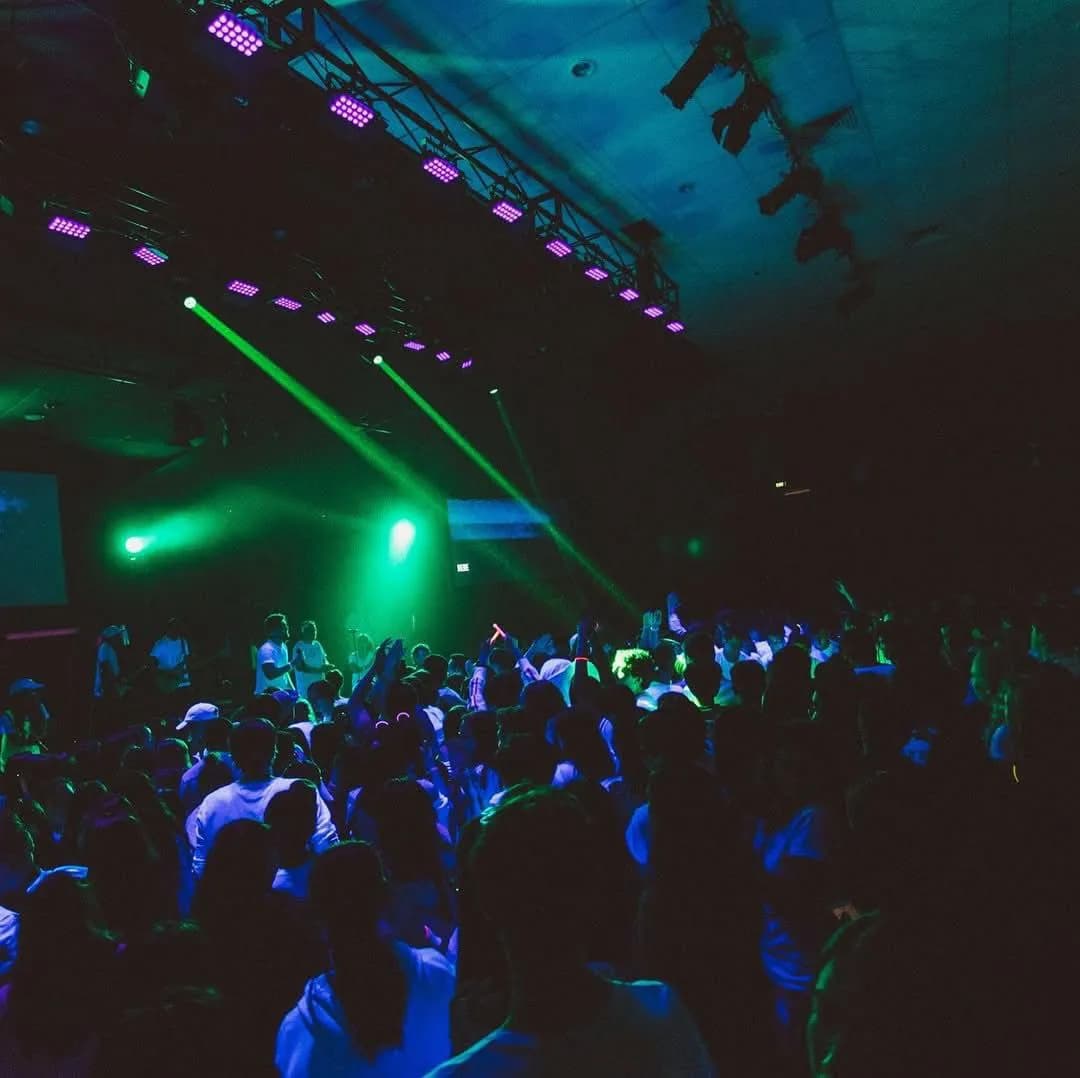 Crowd under cool green spotlights