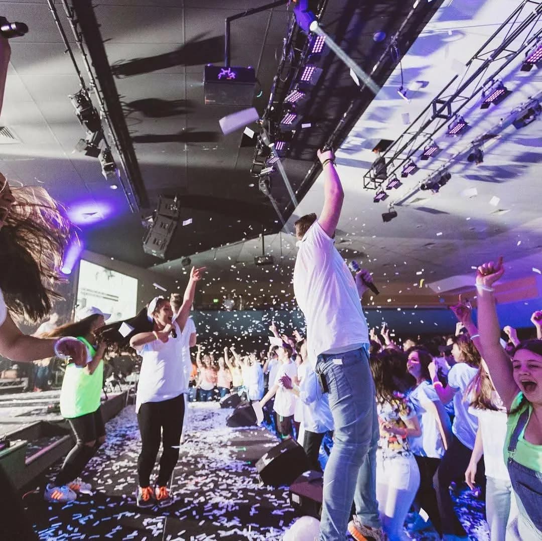 Side view of crowd and band with confetti tickets
