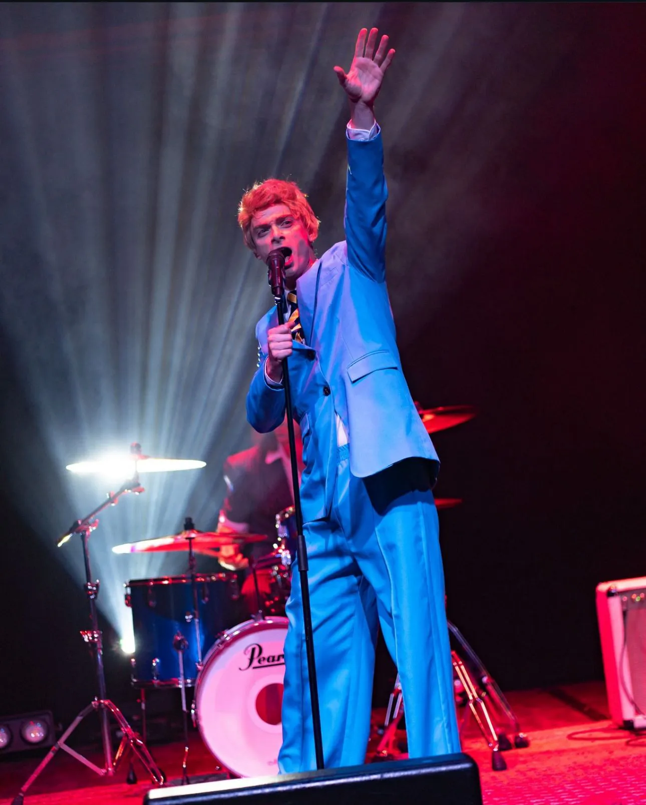 Singer in blue suit with white backlight and red wash light